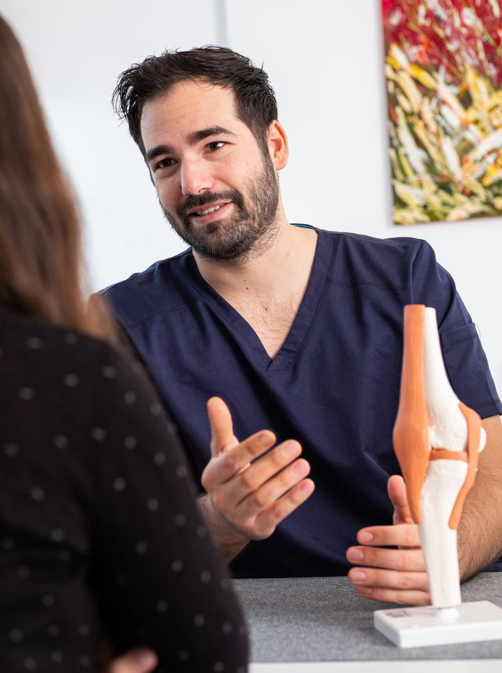 Dr. Patrik Shnawa erklärt Kniearthrose am anatomischen Kniemodell